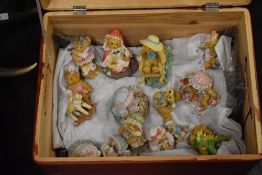 A collection of Cherished teddies figures in a pine wood box