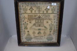 An early Victorian religious needle work sampler decorated with plants and architecture
