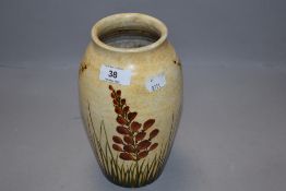 An art deco pottery vase hand decorated with floral scenes by Radford