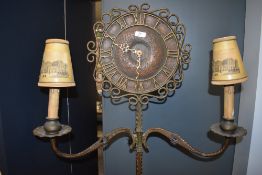 A 1930's arts and crafts inspired combined standard lamp and clock, having bronzed brass twisted and