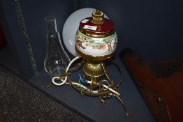 A brass and ceramic ceiling light pendant in the form of an oil lamp having hunting theme design