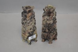 A pair of mirrored soapstone hand carved candle sticks with carp and foliage designs