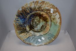 A modern studio pottery ceramic charger plate having a nature inspired glaze by John Calver