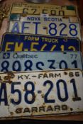 Five American and Canadian license car number plates in pressed tin farm truck etc