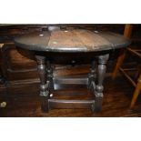 An oak side table in a dark stain having fold out and swivel top