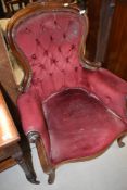 A Victorian button back armchair having dralon uphostery on scroll frame