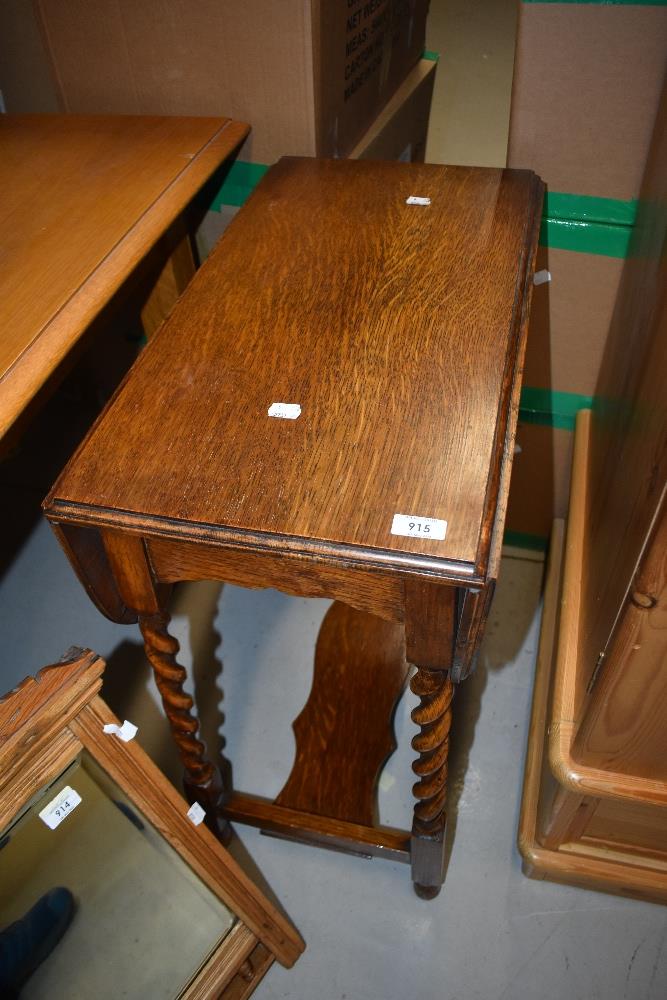 An early 20th Century oak drop leaf occasional table having twist leg frame