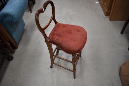 A late Victorian draughtsman or writers stool having low balloon back and turned legs