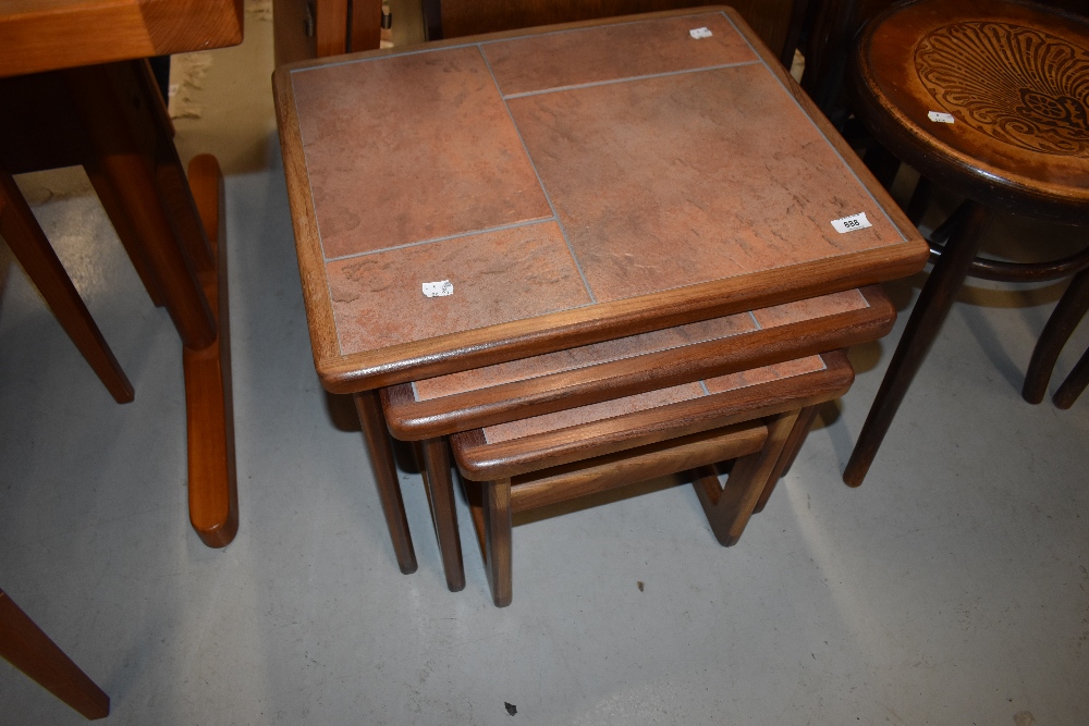 A vintage teak and tile top nest of three tables