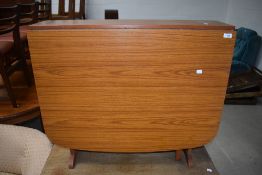 A mid century drop leaf dining or utility table