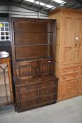 A 20th century oak book case cupboard with carved frontage