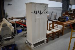 A vintage oak wardrobe on pedestal base being painted shabby chic with bird decoration