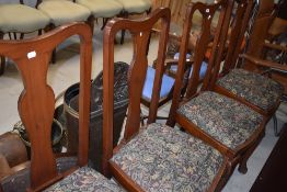 A set of four early 20th Century mahogany dining chairs having vase backs, drop in seats and