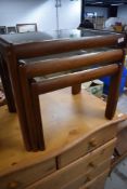 A vintage teak and glass nest of three tables