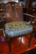 An early 20th Century stained frame armchair having bergere back