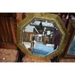 An arts and crafts hand worked octagonal mirror with brass frame and bevel edged glass