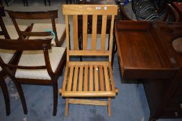 A vintage light stained frame steamer style folding chair
