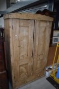 A stripped pine wardrobe with under drawer