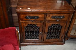 A modern hard wood two drawer and cupboard set with open iron frontage