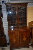 A composite walnut bookcase with double cupboard under, star inlay to base