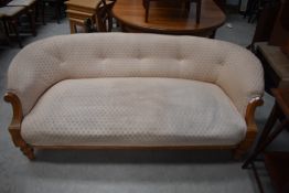 An Edwardian light mahogany framed salon style settee or couch with carved arm detailing