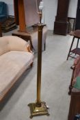 A vintage brass roman column style standard lamp with lion foot base