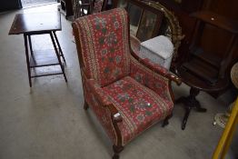 A Victorian low arm chair having mahogany frame with scroll work arms