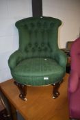 A Victorian button back nursing chair having green upholstery and knurled legs