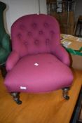 A Victorian button back nursing chair having burgundy upholstery and turned legs