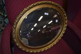 A vintage gilt plaster oval wall mirror