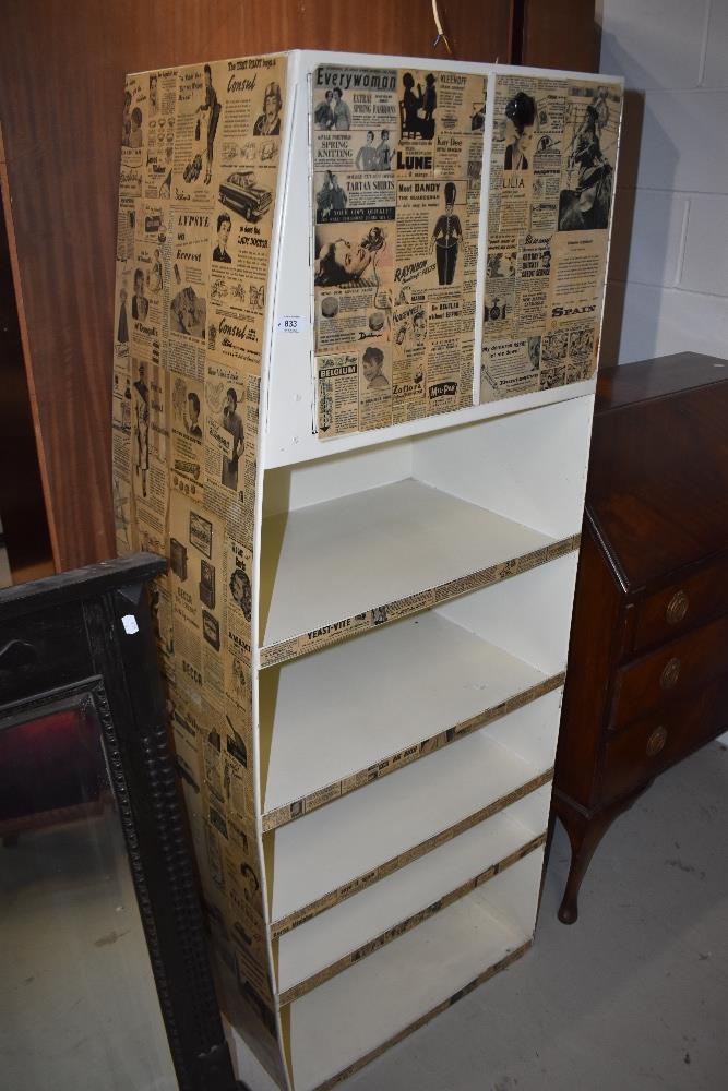 An interestering industrial/commercial shelf unit with upper cupboard, having vintage newspaper