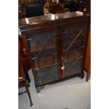 An early 20th Century mahogany display cabinet having astral glazed doors and bracket feet