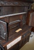 A period oak dresser having court cupboard style back section, naively carved decoration and