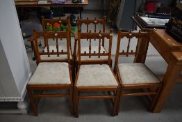 A set of four plus one carver 20th century oak dining chairs having gothic arch back designs