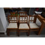 A set of four plus one carver 20th century oak dining chairs having gothic arch back designs