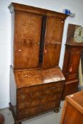 A late 18th century secretaire book case having walnut veneer frontage with original brass handles