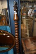An early 20th Century oak standard lamp having cup and cover style base and turned column