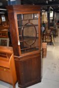 An early 20th Century mahogany corner display with lower cupboard section