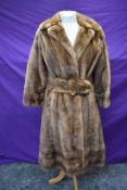 A Fitted mink coat, having half belt to waist an bracelet length sleeves, around 1950s.