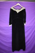 A late 1930s black velvet dress having intricate lace to cuffs and collar, side brass zip,in a