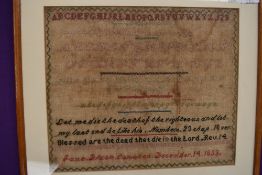 A Victorian sampler dated 1853 by Jane Dixon,Coniston,with religious text and alphabet.