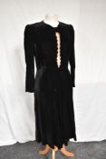 A 1930s black velvet dress having scalloped front and bow detail with pink modesty panel,full length