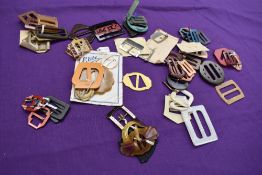 A bag full of vintage and antique buckles, many bright bakelite and early plastic examples.