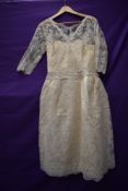 A late 1950s cream lace wedding dress having illusion strapless under dress with tulle lace