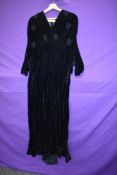 A late 1940s black velvet evening gown with bead detailing and half belt to waist,side metal