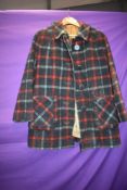 A 1950s tartan jacket having two pockets and large buttons to front, some wear to lining and would