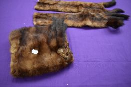 An early 20th century mink muff with tails and faux eyes, lined in chestnut silk, additional