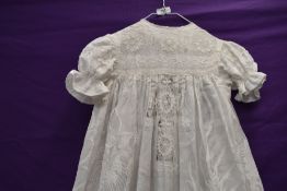 An unusual early 20th century childs gown, having incredible dragon embroidery and lace work.