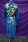 A richly embroidered early 20th century blue kimono dressing gown having incredible floral detail to