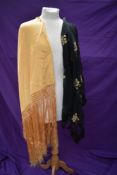 A deeply fringed golden/apricot coloured 20th century shawl and another sheer fine black shawl